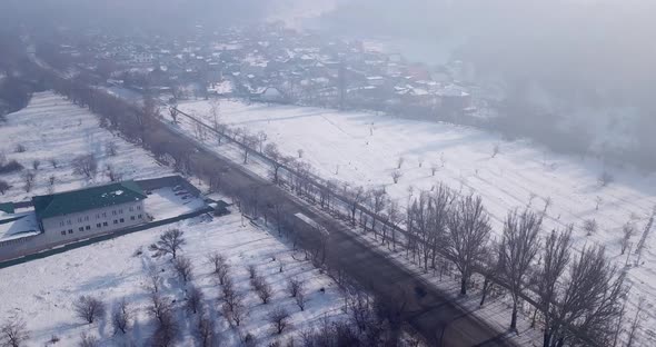 Winter Village and Highway with Cars in the Fog