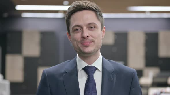 Portrait of Businessman with Laptop Smiling in Camera