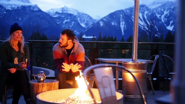 Couple interacting nearby campfire