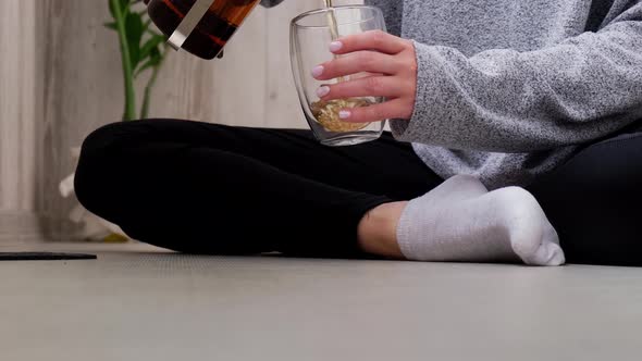 Young Millennial Blonde Woman Drinking Tea and Doing Yoga Exercise Stretching Fitness at Balcony