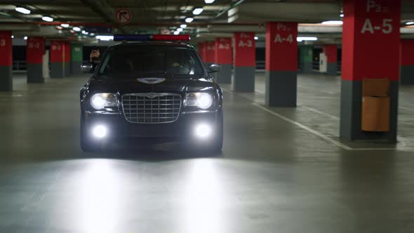 Policemen Riding in Patrol Car on Underground Parking