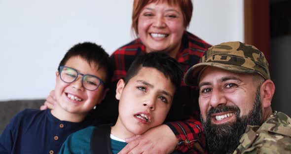 Happy veteran soldier man hugging his family after returning from military service at home