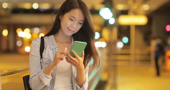 Woman Looking at Mobile Phone in The Evening 