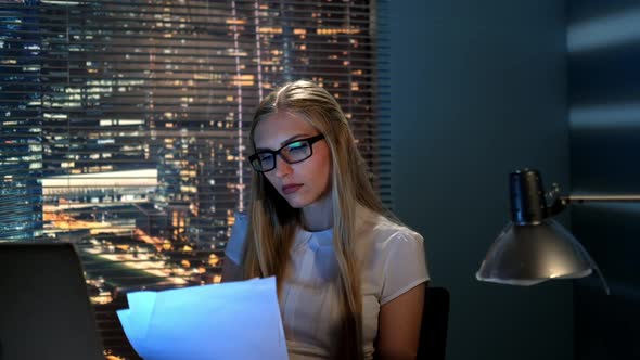 Close-up of Beautiful Teacher in Eyeglasses Checking Somebody's Summary at Home