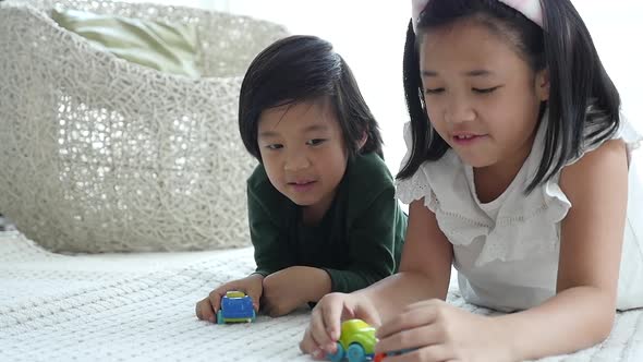 Cute Asian Children Playing Toy Cars Together