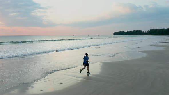 Jogger on a tropical beach at sunset
