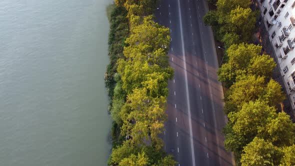 Traffic On The Autumn Alley By The Riverside Highway At The Sunset