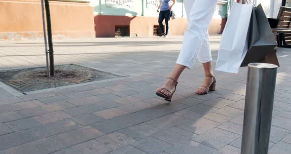 Bottom View of Shopping Bags in Hands. Beautiful, Young Woman Walks Through the City Shopping with