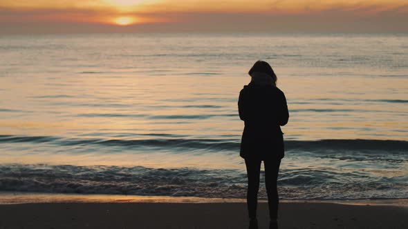 Silhouette of a Young Woman on a Background of the Sea