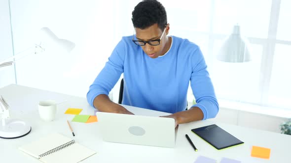 African Designer Working On Laptop in Office,