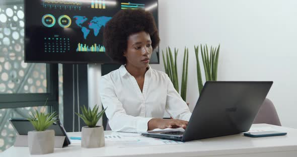 Black-Skinned Businesswoman with Afro Hairstyle which Working on Laptop in Office