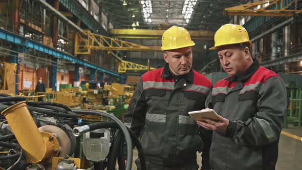 Plant Workers With Tablet Having Conversation