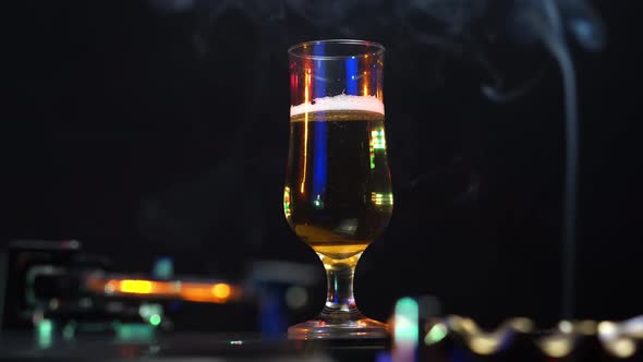 Disco Lights on Beer Glass Cigarette Smoke and Gramophone With Vinyl Record