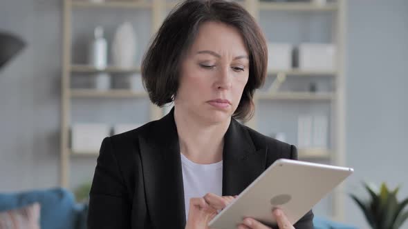 Senior Old Businesswoman Using Tablet for Browsing Internet