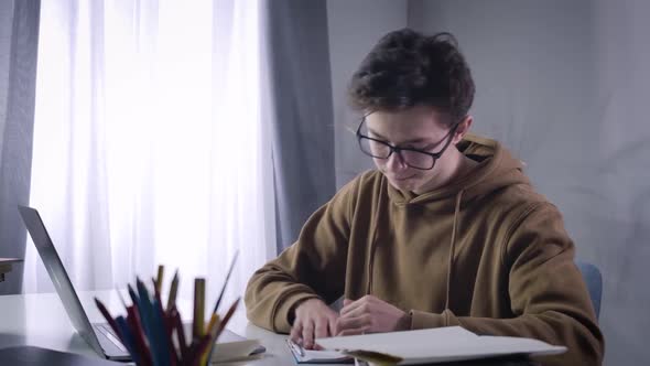 Close-up of Disappointed Caucasian Brunette Boy Tearing Off Workbook Page, Crumpling It and Throwing