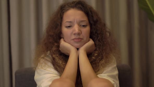 Depressed Mixed Race Young Woman with Long Curly Hair Cries