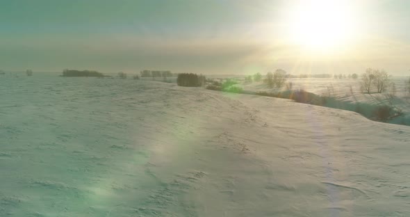 Aerial View of Cold Winter Landscape Arctic Field Trees Covered with Frost Snow Ice River and Sun