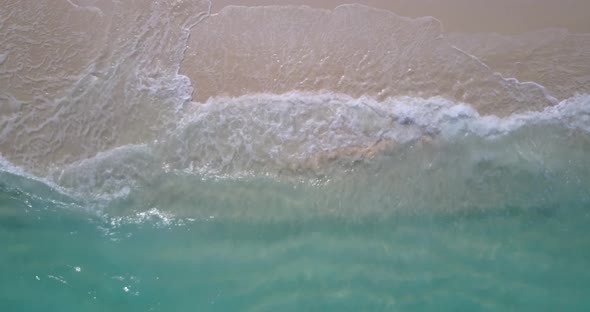 Wide birds eye clean view of a sandy white paradise beach and aqua turquoise water background 