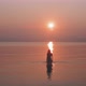 Silhouette of a woman walking in a calm sea staring at the sunrise - VideoHive Item for Sale