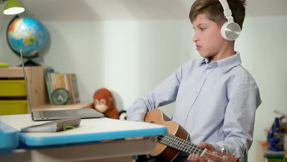 Boy Sitting At Laptop At Home