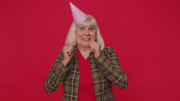 Cheerful Positive Senior Woman in Cone Festive Hat Dancing Having Fun Celebrating Birthday Party