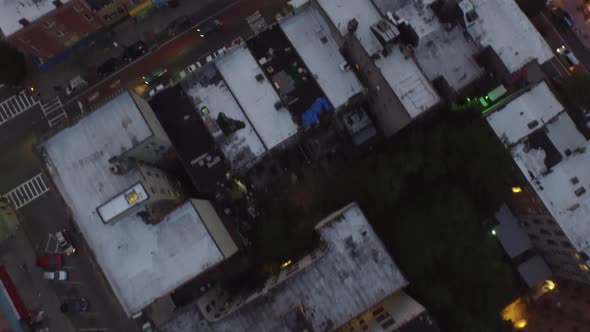 Overhead evening aerial flying over Brooklyn rooftops with cars driving the streets of NYC 4K