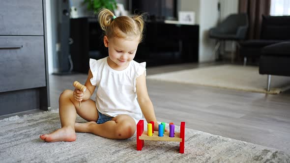 Cute Caucasian Little Girl Playing on the Floor at Home with Eco Wooden Toys