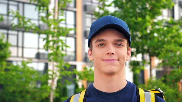 Close Up Smiling Young Man Courier Delivery with Thermal Backpack Looking Camera