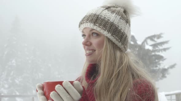 Young woman holding coffee cup and enjoying coffee during winter