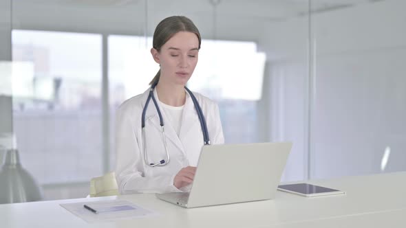 Disappointed Young Female Doctor Doing Thumbs Down in Office 