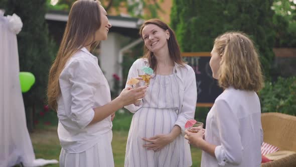 Portrait of Caucasian Happy Pregnant Woman Smiling Talking with Girls Standing on Backyard