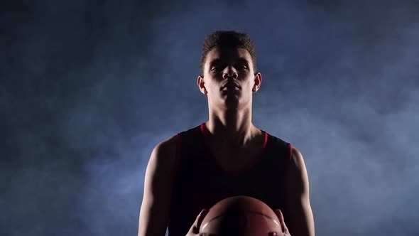 Portrait of a Young African American Basketball Player in a Dark Smoky Studio Under the Spotlight