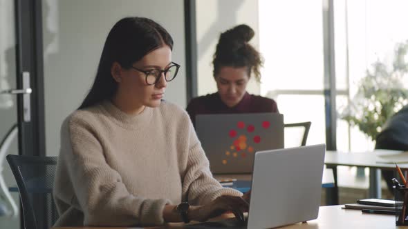 Beautiful Businesswoman Typing on Laptop in Office