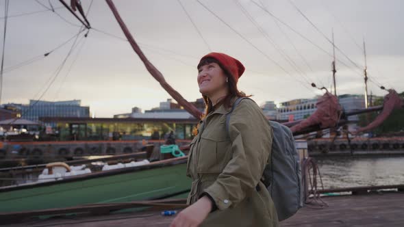 A Young Woman Walks Along the Embankment