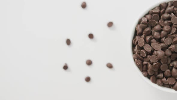 Video of overhead view of bowl of chocolate chip over white background