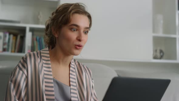 Surprised Woman Talking Video Conference with Friend in Pajamas Home Closeup