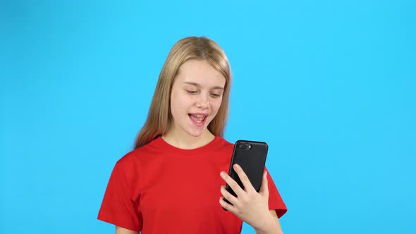 Pretty Little Girl Holding a Phone and Speaking with Someone By Video Calling