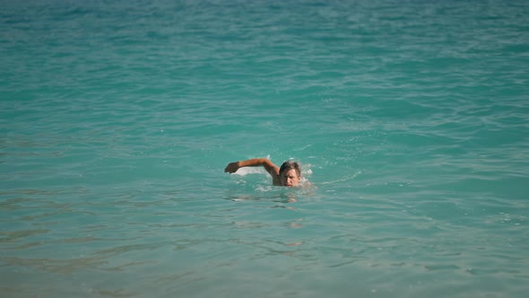Sportsman Athletic Man Swims in Turquoise Water of Mediterranean Sea in Oludeniz Beach in Aegean Sea