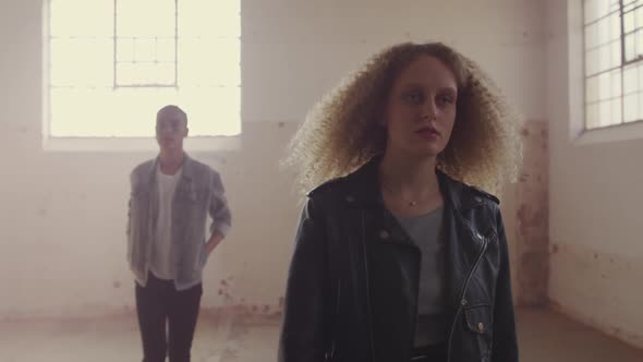 Fashionable young man and woman in an abandoned warehouse