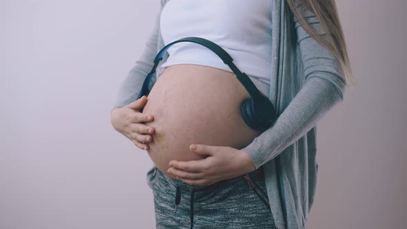 Pregnant Woman Listens To Music Stoking Tummy at Home