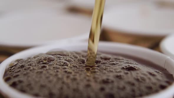 Strong black tea is poured into a paper disposable cup