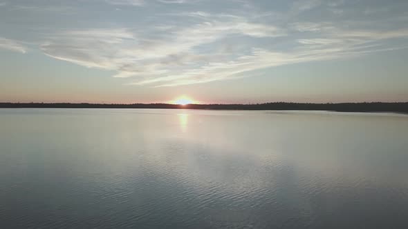 Flight over the expanse of water. Sunset on the lake.