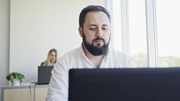 Young Employee Looking at Computer Monitor During Working Day in Office