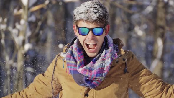 Happy Teenager Throwing Snow Up in Front of Camera