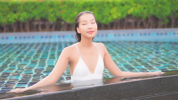 Young asian woman enjoy around outdoor swimming pool for leisure