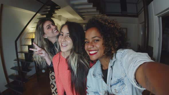 Happy Women Taking Selfie and Looking at Phones Camera