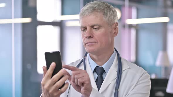 Portrait of Middle Aged Doctor Scrolling on Cellphone