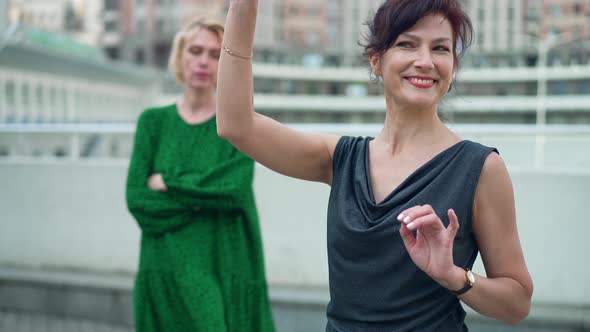 Portrait of Confident Woman Looking Away Winking Smiling As Jealous Bad Friend with Crossed Hands