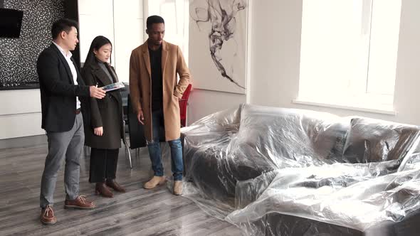 Realtor Explaining Agreement To Couple In New Apartment