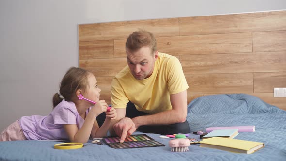 Dad and Daughter are Preparing for Halloween are Going to Do Bright Makeup